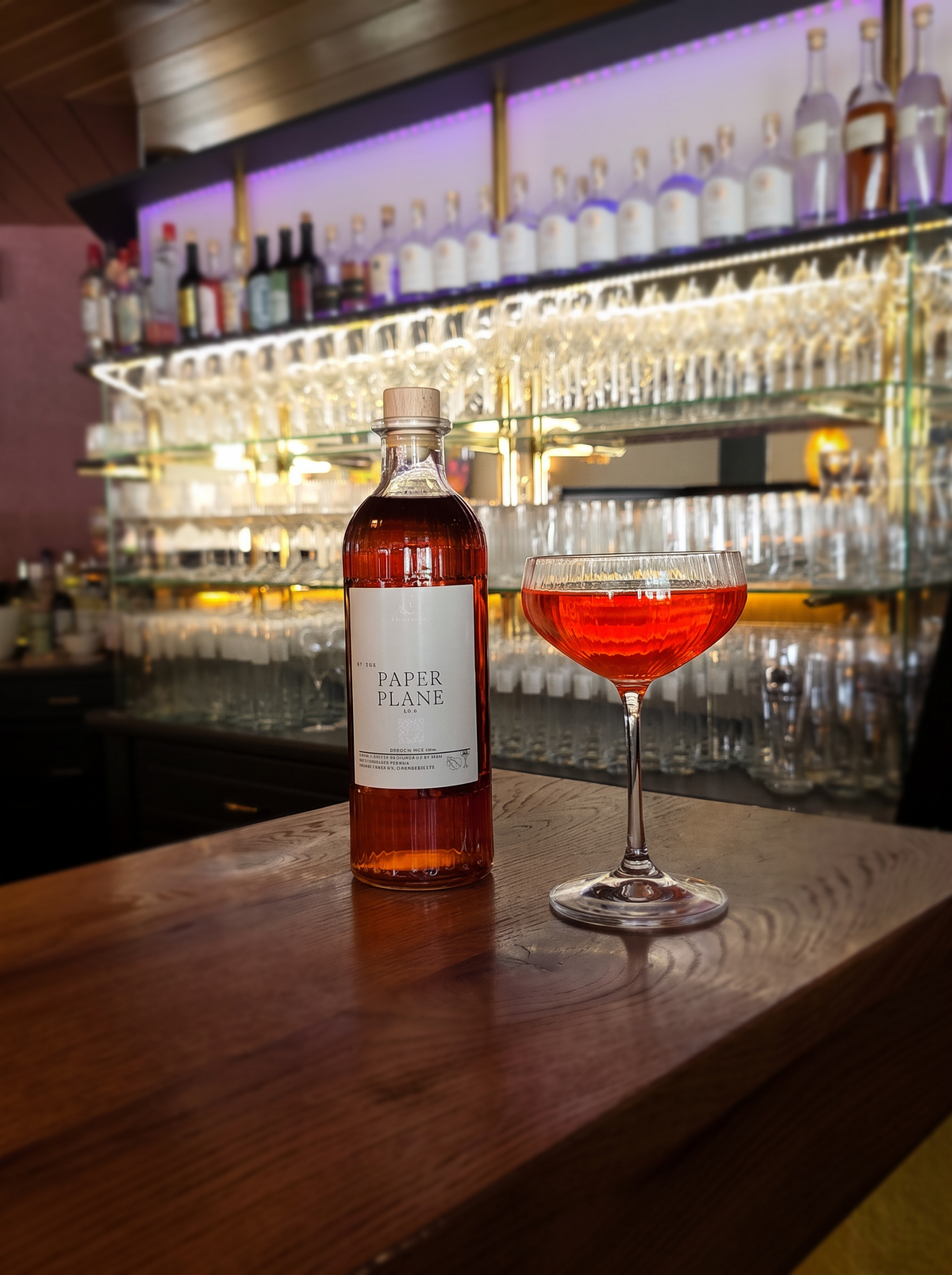 Paper Plane Prebatch Erasmus Collection – Flasche und Coupe-Glas an der Bar